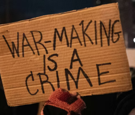 A US protester holds placards reading ‘’war making is a crime’’