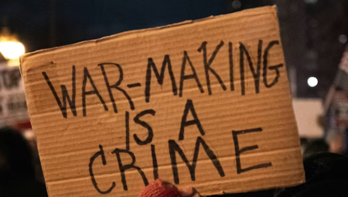 A US protester holds placards reading ‘’war making is a crime’’