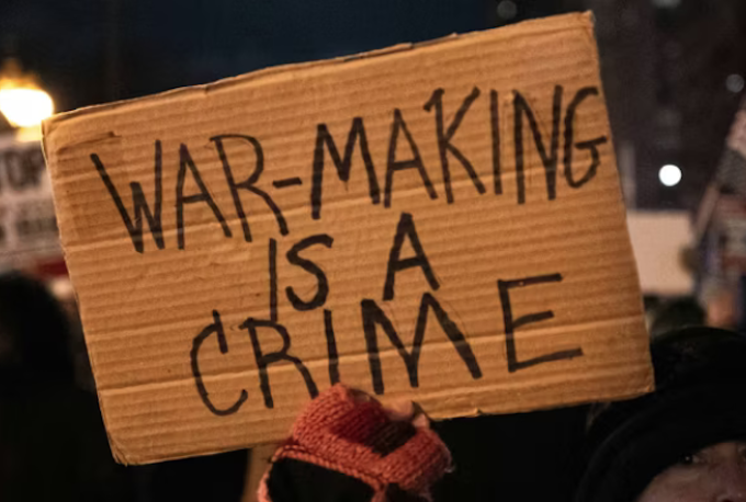 Warmaking CDreams 680wide A US protester holds placards reading ‘’war making is a crime’’