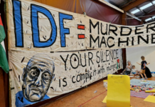 An "IDF = Murder Machine" banner at the "Banners for Humanity" exhibition