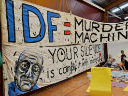 An "IDF = Murder Machine" banner at the "Banners for Humanity" exhibition