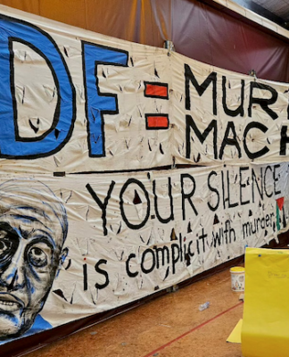 An "IDF = Murder Machine" banner at the "Banners for Humanity" exhibition