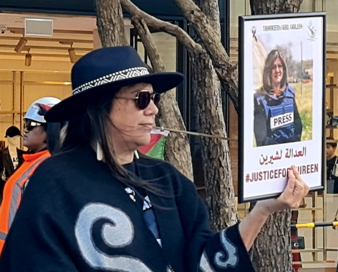 PSNA organiser Leeann Wahanui-Peters holds aloft the photo of assassinated Palestinian-American journalist Shireen Abu Akleh