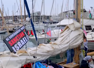 Global Sumud Flotilla heads from Barcelona to break Gaza blockade A "New Zealand government must sanction Israel" banner flutters on one of the Global Sumud Flotilla boats