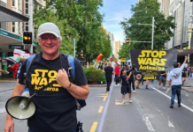Palestine Solidarity Network Aotearoa's Neil Scott and protesters marching in the Stop Wars Aotearoa rally