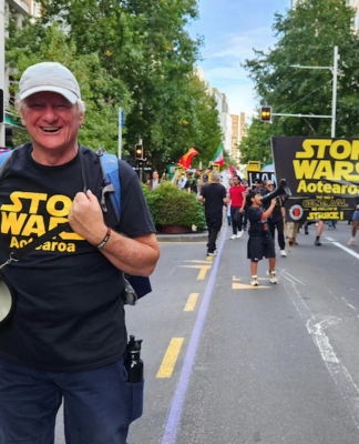 Palestine Solidarity Network Aotearoa's Neil Scott and protesters marching in the Stop Wars Aotearoa rally