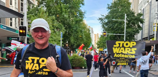 Palestine Solidarity Network Aotearoa's Neil Scott and protesters marching in the Stop Wars Aotearoa rally