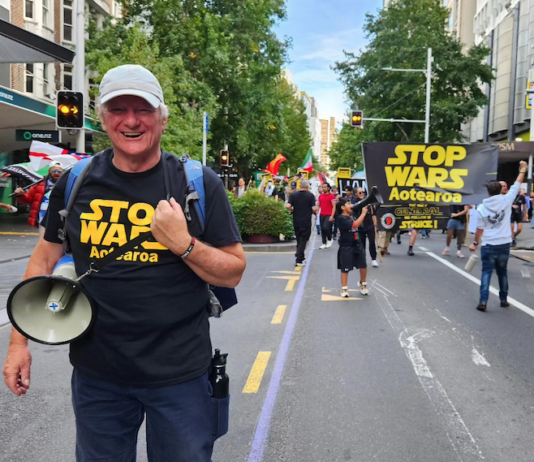 Palestine Solidarity Network Aotearoa's Neil Scott and protesters marching in the Stop Wars Aotearoa rally