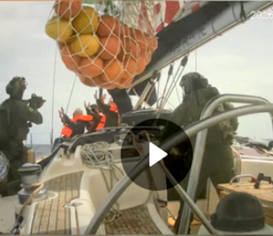 Israeli soldiers board a Gaza-bound humanitarian aid flotilla vessel and hold the crew at gunpoint