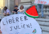 Julien Blondel's niece holds a "free Julien!" placard in French with a Palestinian watermelon logo