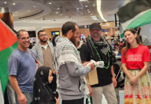 Olivia Coote presents a welcome home koha to Global Sumud Flotilla activists Mousa Taher (centre) and Hāhona Ormsby (black cap) at Auckland International Airport