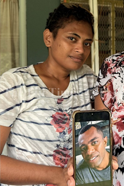 A smartphone with an image of Sakiasi Ose Radravu is held up by his partner Patrica Baleturaga
