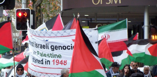 New Zealanders warned not to transit through MidEast as Trump threatens further strikes Iranian and Palestinian flags at a New Zealand rally against the war on Iran and the Gaza genocide