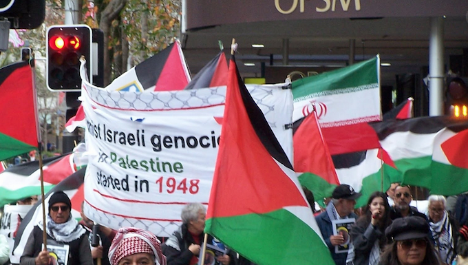 New Zealanders warned not to transit through MidEast as Trump threatens further strikes Iranian and Palestinian flags at a New Zealand rally against the war on Iran and the Gaza genocide