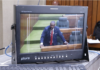 A PNG Parliament press gallery monitor shows Opposition Leader James Nomane speaking during debate following the tabling of the Bougainville referendum result
