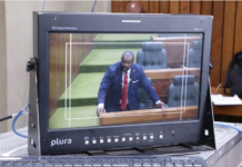 A PNG Parliament press gallery monitor shows Opposition Leader James Nomane speaking during debate following the tabling of the Bougainville referendum result