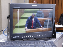 A PNG Parliament press gallery monitor shows Opposition Leader James Nomane speaking during debate following the tabling of the Bougainville referendum result