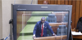 A PNG Parliament press gallery monitor shows Opposition Leader James Nomane speaking during debate following the tabling of the Bougainville referendum result