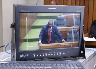 A PNG Parliament press gallery monitor shows Opposition Leader James Nomane speaking during debate following the tabling of the Bougainville referendum result