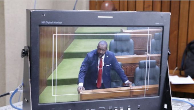 A PNG Parliament press gallery monitor shows Opposition Leader James Nomane speaking during debate following the tabling of the Bougainville referendum result
