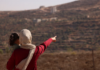 Trapped Palestinian Refqa Hassan watches as Israeli settlers have besieged her family home
