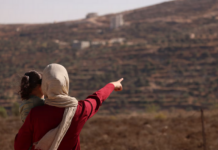 Trapped Palestinian Refqa Hassan watches as Israeli settlers have besieged her family home