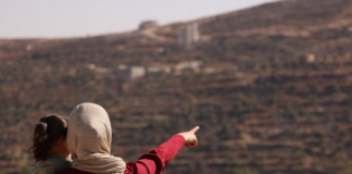 Trapped Palestinian Refqa Hassan watches as Israeli settlers have besieged her family home