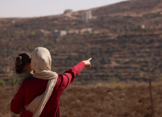 Trapped Palestinian Refqa Hassan watches as Israeli settlers have besieged her family home