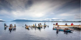 Islanders in outrigger canoes selling tropical fruits off Dobu in the Solomon Sea