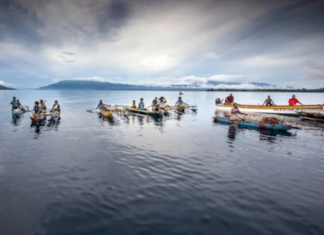 Debt in the Pacific – systemic and current threats to regional economic sovereignty Islanders in outrigger canoes selling tropical fruits off Dobu in the Solomon Sea