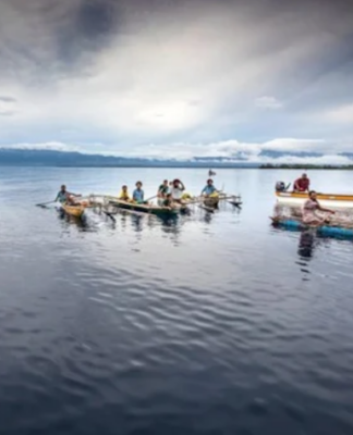 Islanders in outrigger canoes selling tropical fruits off Dobu in the Solomon Sea