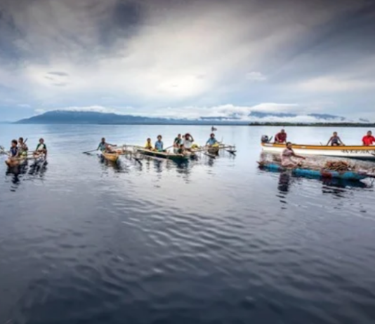 Islanders in outrigger canoes selling tropical fruits off Dobu in the Solomon Sea