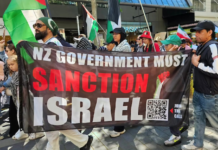 A banner at the Auckland "global day of action" march calling on the New Zealand government to sanction Israel