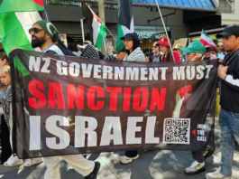 A banner at the Auckland "global day of action" march calling on the New Zealand government to sanction Israel