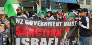 A banner at the Auckland "global day of action" march calling on the New Zealand government to sanction Israel