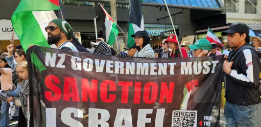 A banner at the Auckland "global day of action" march calling on the New Zealand government to sanction Israel