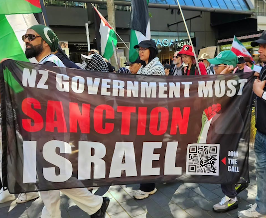 A banner at the Auckland "global day of action" march calling on the New Zealand government to sanction Israel