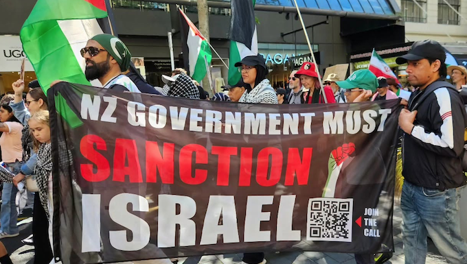 A banner at the Auckland "global day of action" march calling on the New Zealand government to sanction Israel
