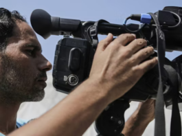 Palestinian journalists work with cameras, laptops and limited equipment from makeshift press areas