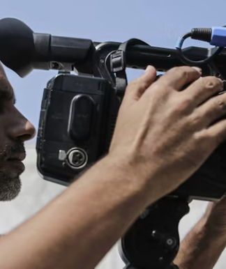 Palestinian journalists work with cameras, laptops and limited equipment from makeshift press areas